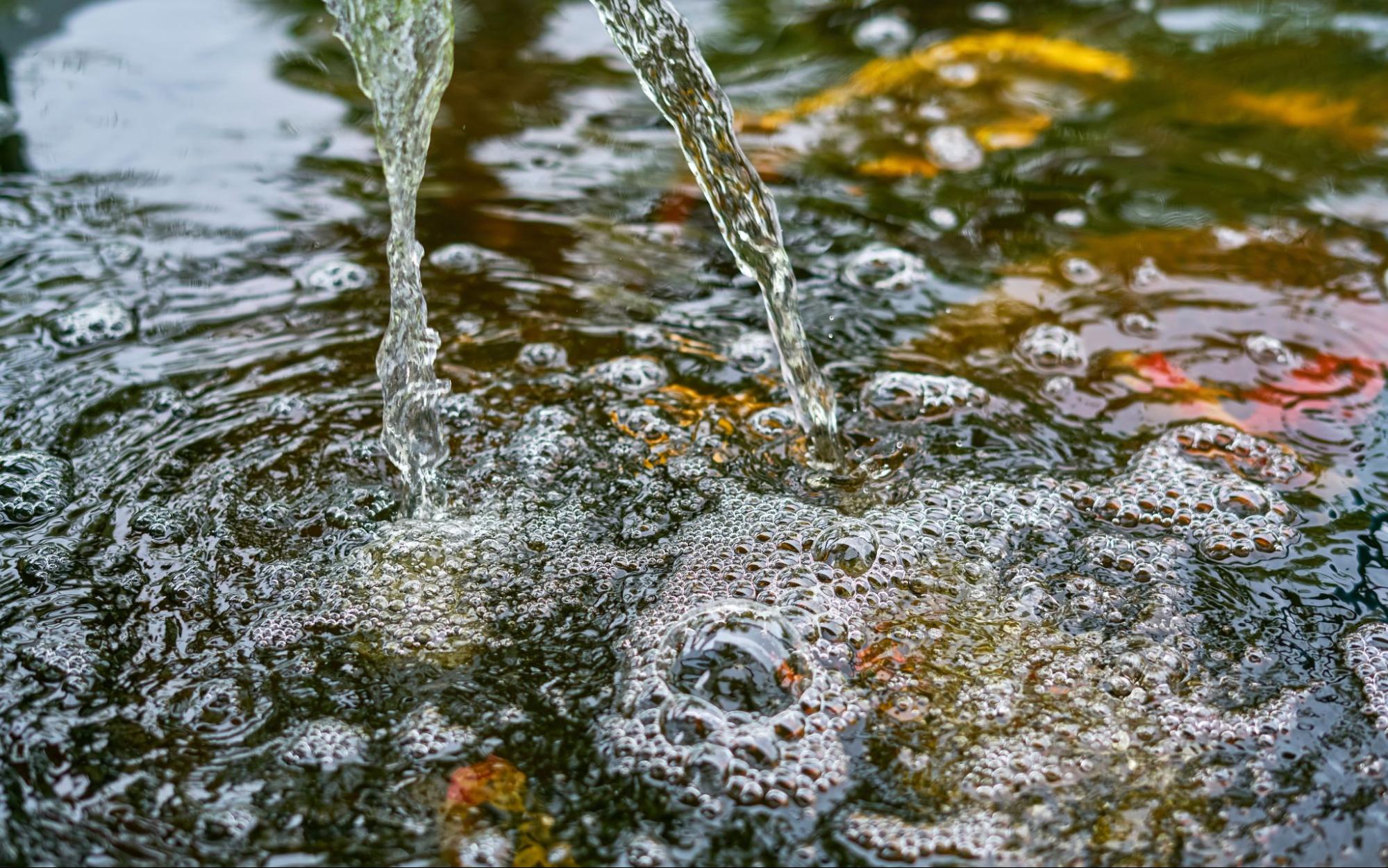 Detail van vijverwater met luchtbellen en filtering voor een gezonde vijver op de beste plek